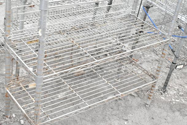 Chrome finish 5-tier shelving unit with visible rust, wire shelves, sturdy frame, requires buyer dismantle. Consider freight costs.