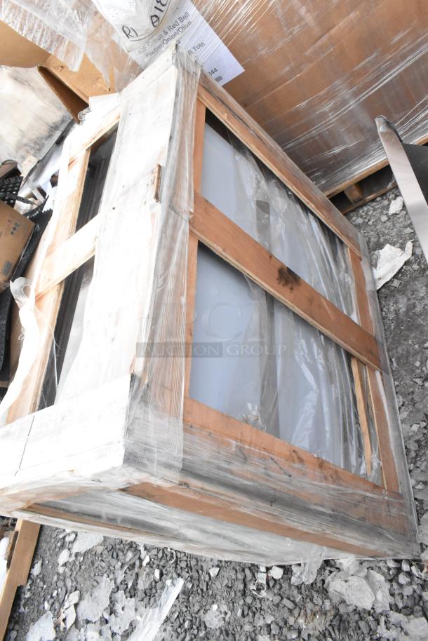 Regency 36" stainless steel wall cabinet, new with scratches and dents, sliding doors, packaged in a wooden frame.