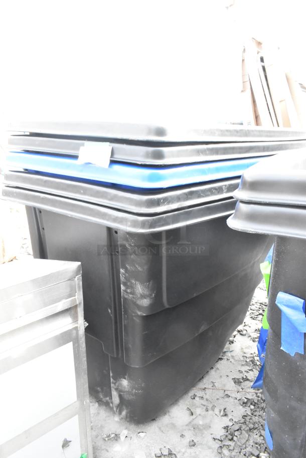 Alt text: Black poly tilt trucks with minor scratches and dents, stackable design. Includes blue-lined edges. Brand new, auction for 7 units.