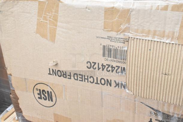 Cardboard box labeled with "NSF" and "600SM242412C," indicating Regency mop sink, 24"x24"x12". Box shows scratches and dents.