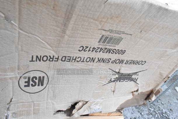 Regency 16-gauge stainless steel mop sink box, model 600SM242412C, showing visible scratches and dents on packaging.