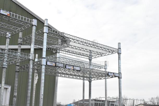 Two chrome finish wire shelving units outdoors, shown assembled. Tags on shelves, buyer to dismantle for shipping.