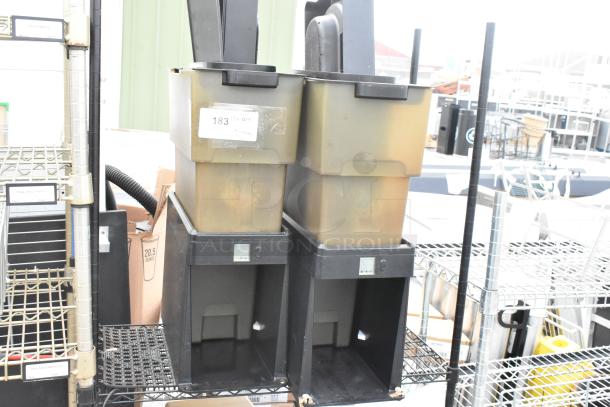 Black and tan 2-tier wire shelving unit with beverage dispensers. Buyer must dismantle. Tags indicate item quantity.