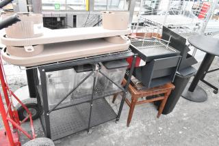 Lot of items including a tan chair, black shelving unit with containers, and various accessories. Mix of metal and wood.