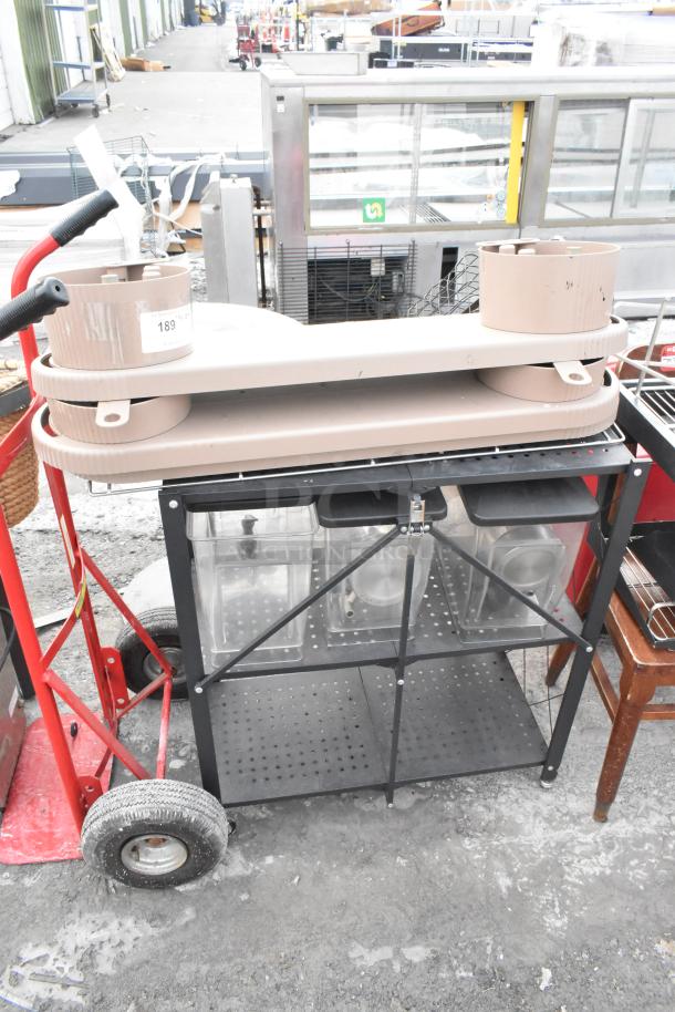 Lot of various items including a black shelving unit and other miscellaneous objects. Items show signs of wear. Tag numbered 189 visible.