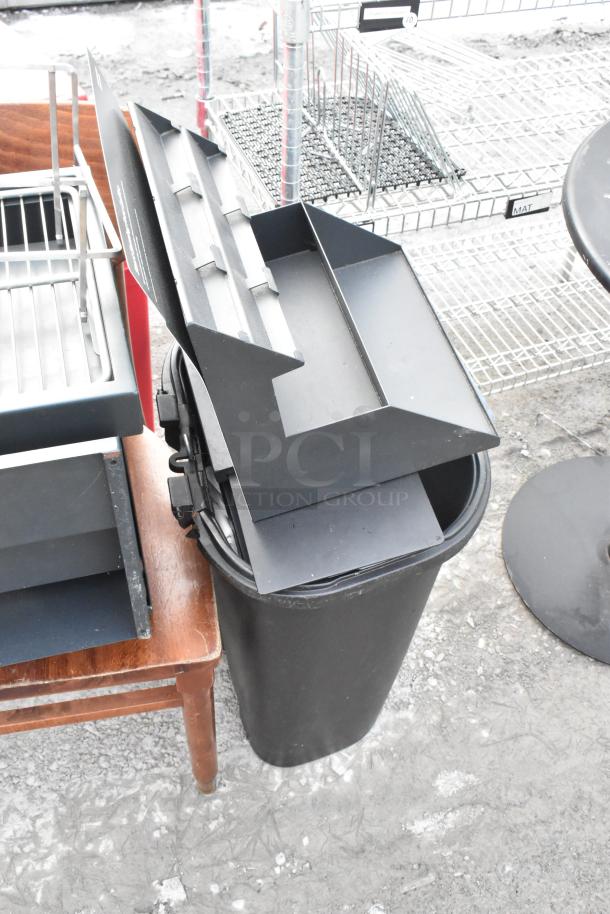 Lot of various items including a wooden chair, black shelving unit, and storage bins. Items show signs of wear.