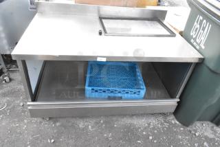 Stainless steel table with under shelf, commercial casters, includes a transparent top panel and blue storage tray. Visible ID tag.