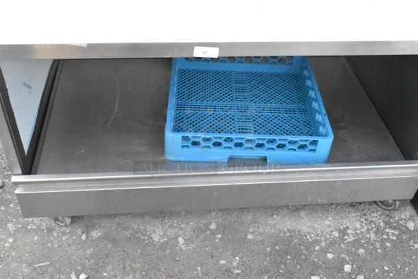 Stainless steel table with under shelf, commercial casters, includes blue tray. Ideal for kitchen use, good condition.