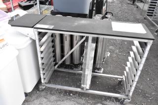 Metal commercial double pan rack on casters; multiple shelves, sturdy design, used for kitchen or bakery storage.