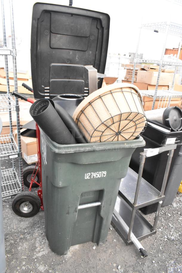 Two poly trash cans containing baskets, floor mats, and various items. Visible marking: "U2 745079".
