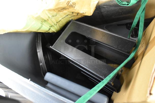 Two poly trash cans filled with various contents, including baskets, floor mats, and a yellow bag. Visible green strap on side.