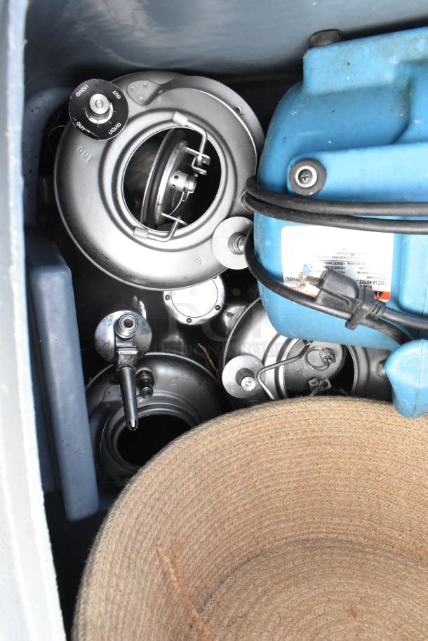 Poly trash can containing a blue fan, metal components with dials, and a woven basket. Items show slight wear.