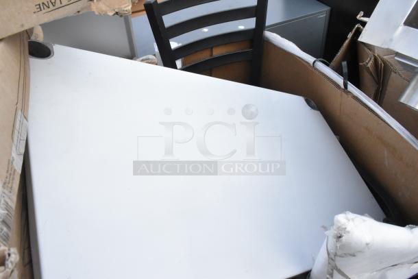 8 new scratch and dent items including a metal baking pan, chair frame, and table in packaging.