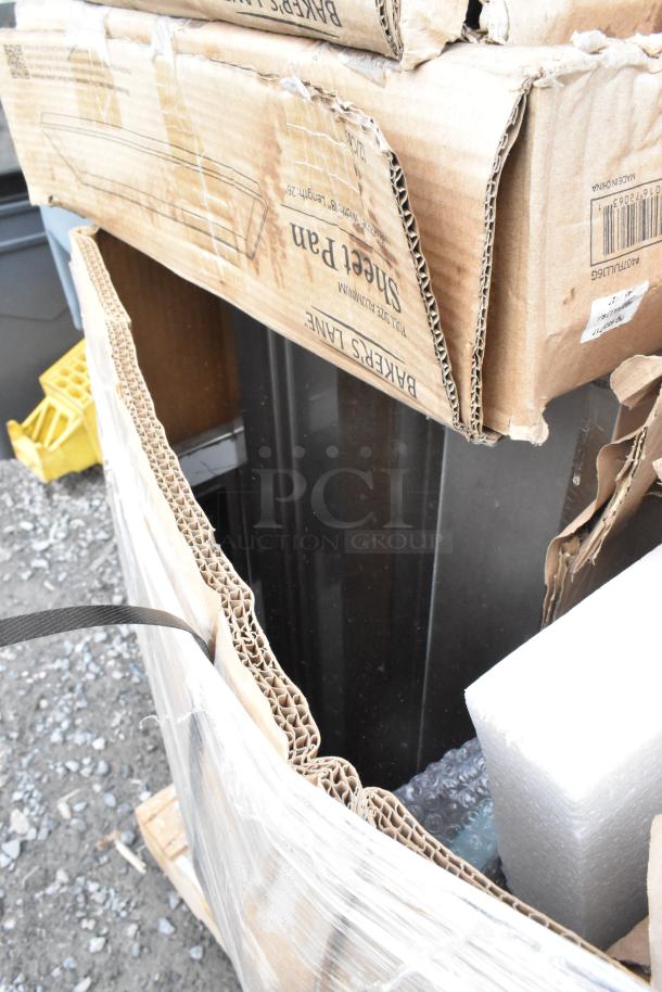 Cardboard boxes containing new, scratch and dent items including metal baking pans. Boxes show signs of wear.