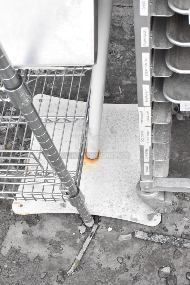 Hand sanitizer dispenser on a white stand, visible rust at base, surrounded by wire shelf and labeled storage rack.