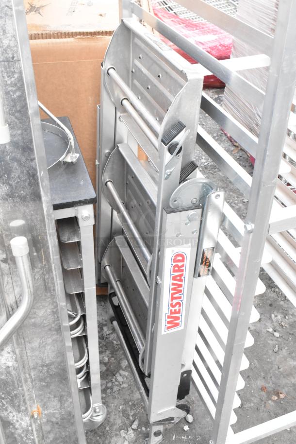 Metal folding table and Westward ladder attachment in good condition, stacked. Westward label visible. Auction item.