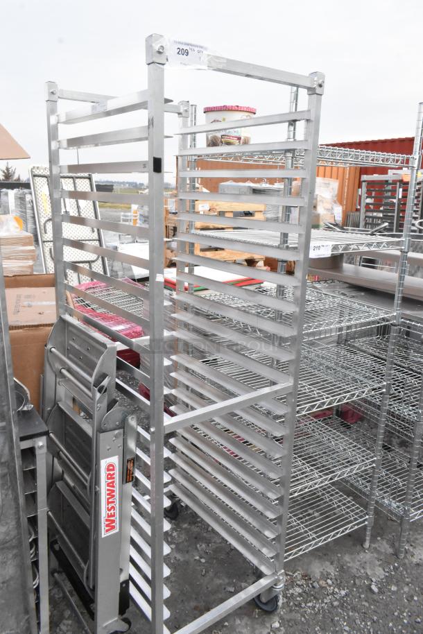 Metal commercial pan transport rack on commercial casters, used, with multiple slots for pans, sturdy construction.