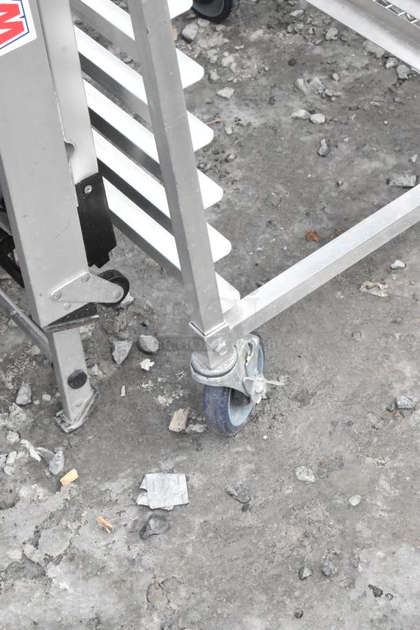 Metal commercial pan transport rack with multiple slots, durable aluminum frame, on swivel commercial casters.