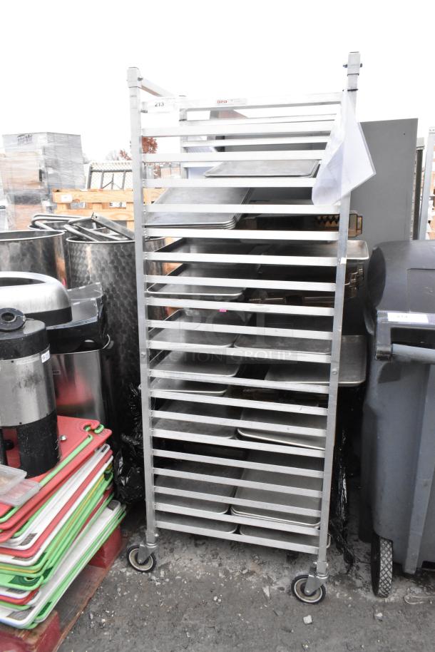 Metal pan transport rack with commercial casters, sturdy construction, multiple shelves, good condition.