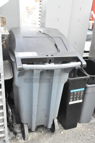 Four trash cans, including a blue bin and Slim Jim container, with wheels and visible recycle markings. Used condition.