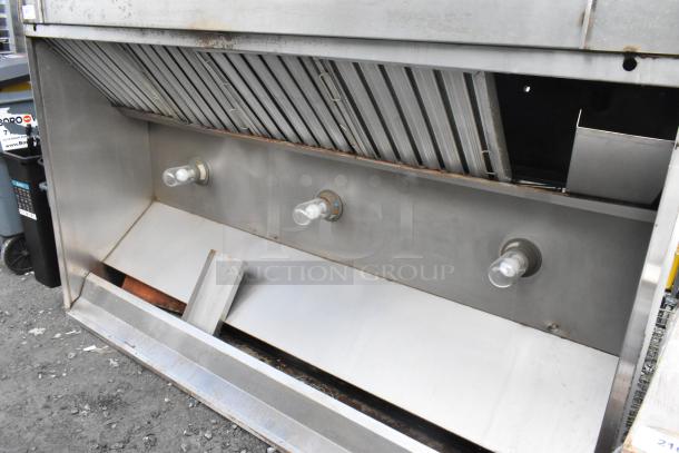 8' metal commercial grease hood with filters and lights, in used condition. Features visible light fixtures and venting filters.