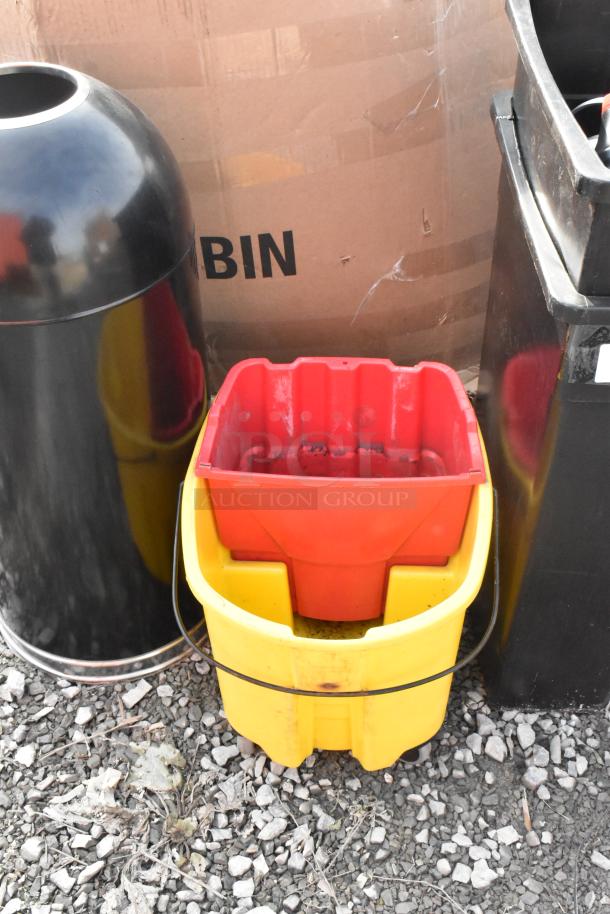 4 items: 2 Slim Jim trash cans, mop bucket, black metal trash can shell. Outdoor setting, used condition.