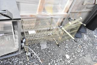 Two tan finish 2-tier wire shelving units on gravel surface. Shelves appear intact. Buyer must dismantle for shipping.