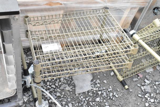 Two tan finish, 2-tier wire shelving units on gravel. Includes label "221" indicating quantity. Buyer disassembly required.