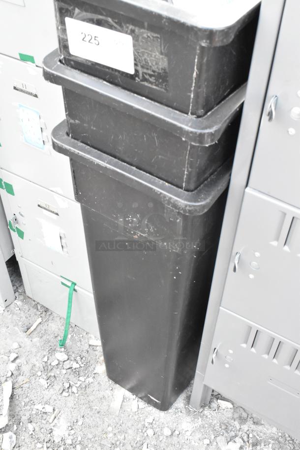 Three black poly Slim Jim trash cans in used condition with some surface wear, stacked vertically, featuring white label marked "225".