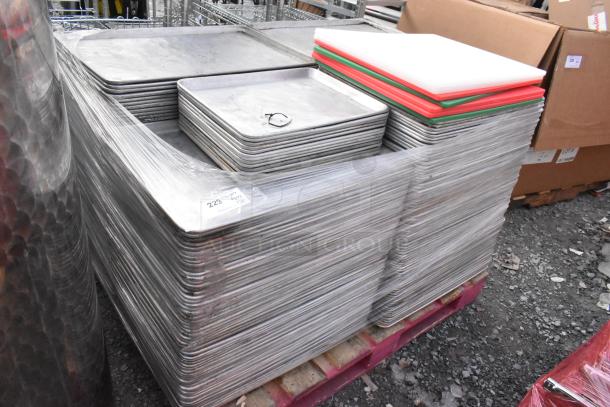 Stack of full and half-size metal baking pans, cutting boards; wrapped pallet; sale tag visible. Total: 180 items.