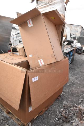 Large stack of cardboard boxes on a pallet, marked "Honeywell," containing scratch and dent items, including Regency mop sink.