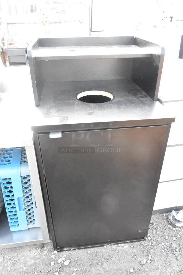 Black trash can shell with trash deposit hole, tray return, door, and poly trash can; good condition.