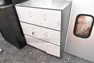 9 cubby locker with metal frame and white doors, some wear and scratches visible. One door has a key lock.