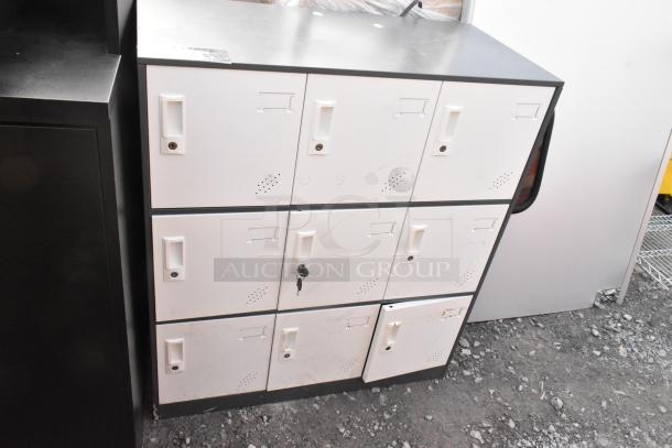9 cubby locker with a black top and white doors, some keys included. Visible wear and markings on surfaces.