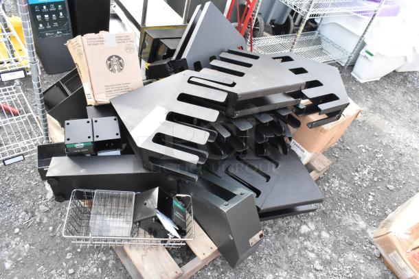 Pallet lot including multiple black lid dispensers, wire baskets, and a Starbucks cardboard box, in used condition.