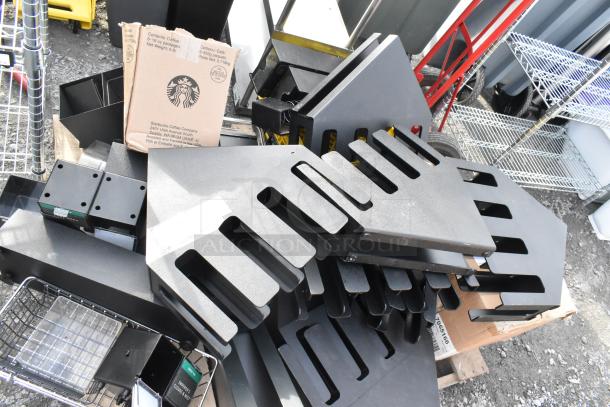 Pallet lot of assorted lid dispensers and items; includes black plastic dispensers and a Starbucks cardboard box.
