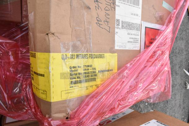 Cardboard box with Glo-Ray Infrared Foodwarmer label showing model GRAH-72D, serial 2853272302, partially covered by red plastic wrap.
