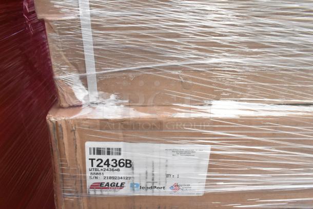 Cardboard boxes wrapped in plastic, labeled "Eagle Group T2436B Work Table." Model: T2436B, S/N: 2109234127.