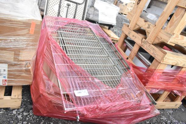Lot of brand new scratch and dent items including wire shelves wrapped in red plastic, on pallets, labeled "249."