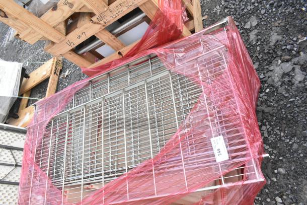 Lot of brand new scratch and dent wire shelves wrapped in red plastic, with visible labels indicating item conditions.