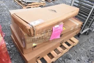 Stack of five boxed items, including Advance Tabco and Hobart, labeled "scratch and dent," on a wooden pallet.