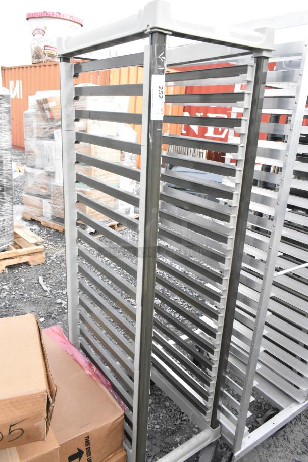 Metal commercial pan transport rack with multiple shelves on durable commercial casters, labeled "252" on side. Rugged condition.