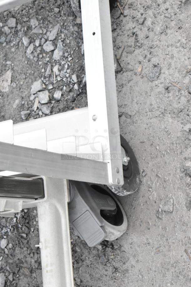 Metal commercial pan transport rack on four sturdy casters, showing durable construction ideal for kitchen use.