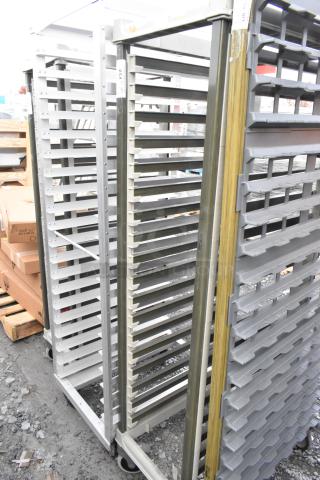 Metal commercial pan transport rack with multiple shelves and sturdy commercial casters. Used for efficient kitchen storage.