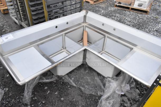 Brand new Steelton 3-compartment corner sink in 18-gauge stainless steel, features two drainboards, 18" x 18" x 12" bowls, no legs.