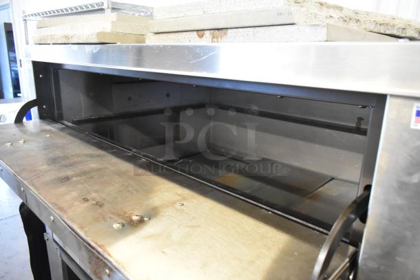 Brand new Peerless stainless steel commercial 2 deck pizza oven with metal legs, minor scratches, durable build.
