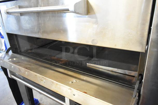 Brand new scratch and dent Peerless stainless steel 2-deck commercial pizza oven, mounted on metal legs.