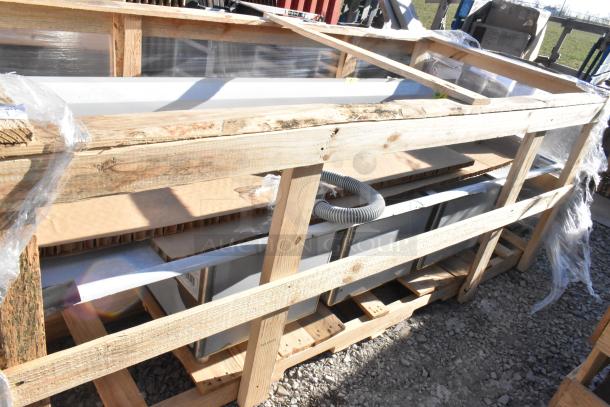 Regency stainless steel 3-bay sink with dual drain boards, scratch and dent new, no legs, protected in wooden frame.