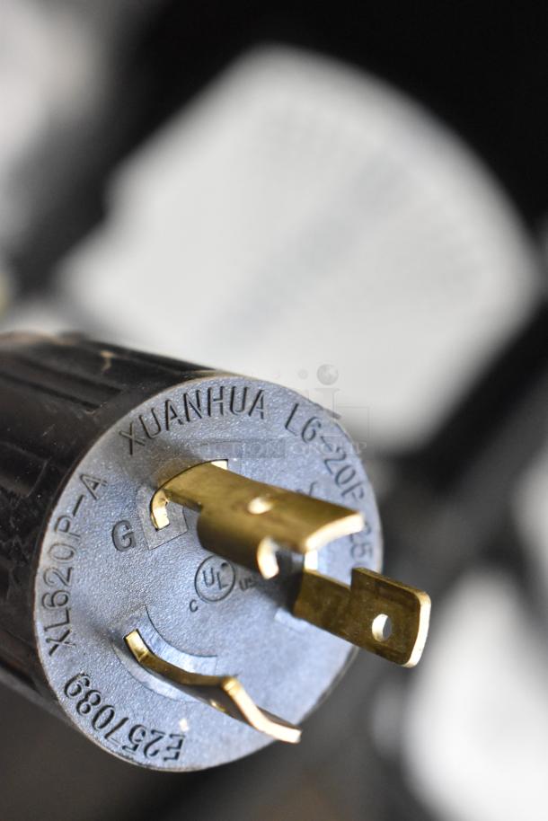 Close-up of electrical plug marked "XUANHUA L6-20P-A", showing prongs and UL certification. Part of Grindmaster unit.