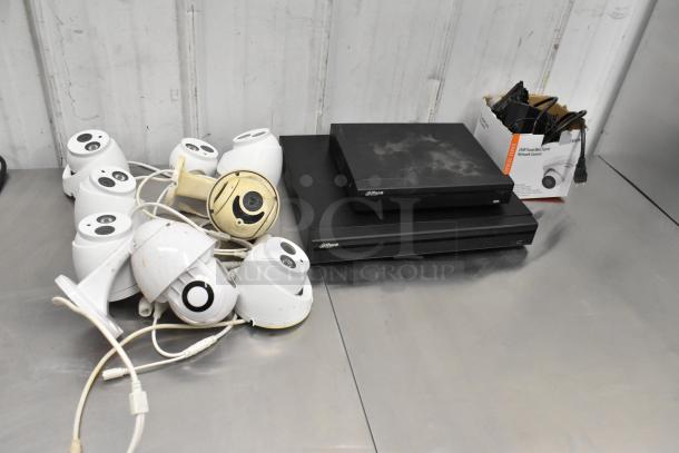 Security camera kit with 8 cameras, 2 Alhua units. Cameras in used condition, some cables present. Alhua logos visible.